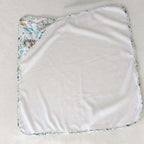Cape de bain bébé blanche avec coin imprimé animaux et feuillages, accessoire enfant artisanal.