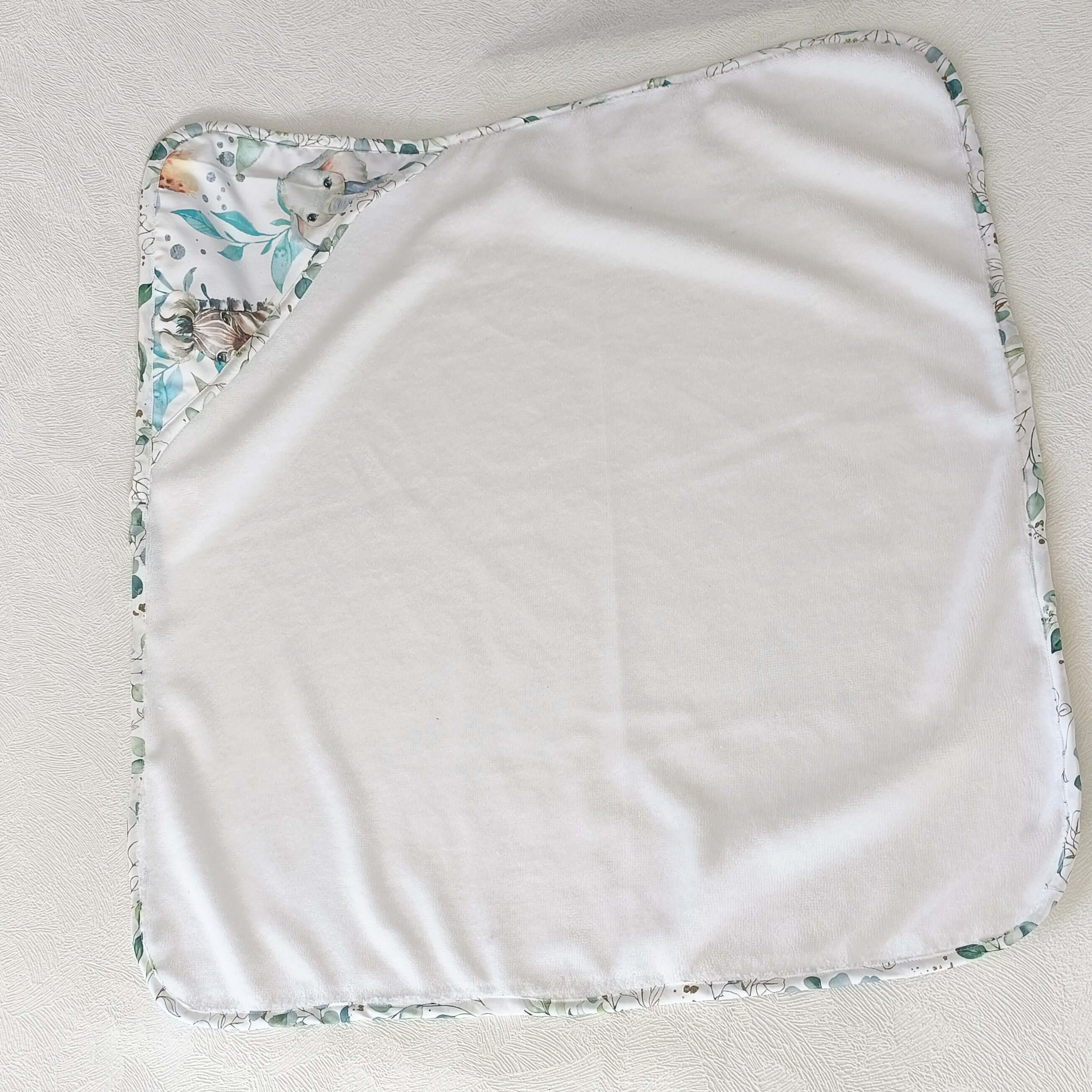 Cape de bain bébé blanche avec coin imprimé animaux et feuillages, accessoire enfant artisanal.