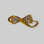 Vue de l'attache ajustable et du crochet de fermeture d'un nœud papillon pré-noué jaune et fleuri sur fond blanc.
