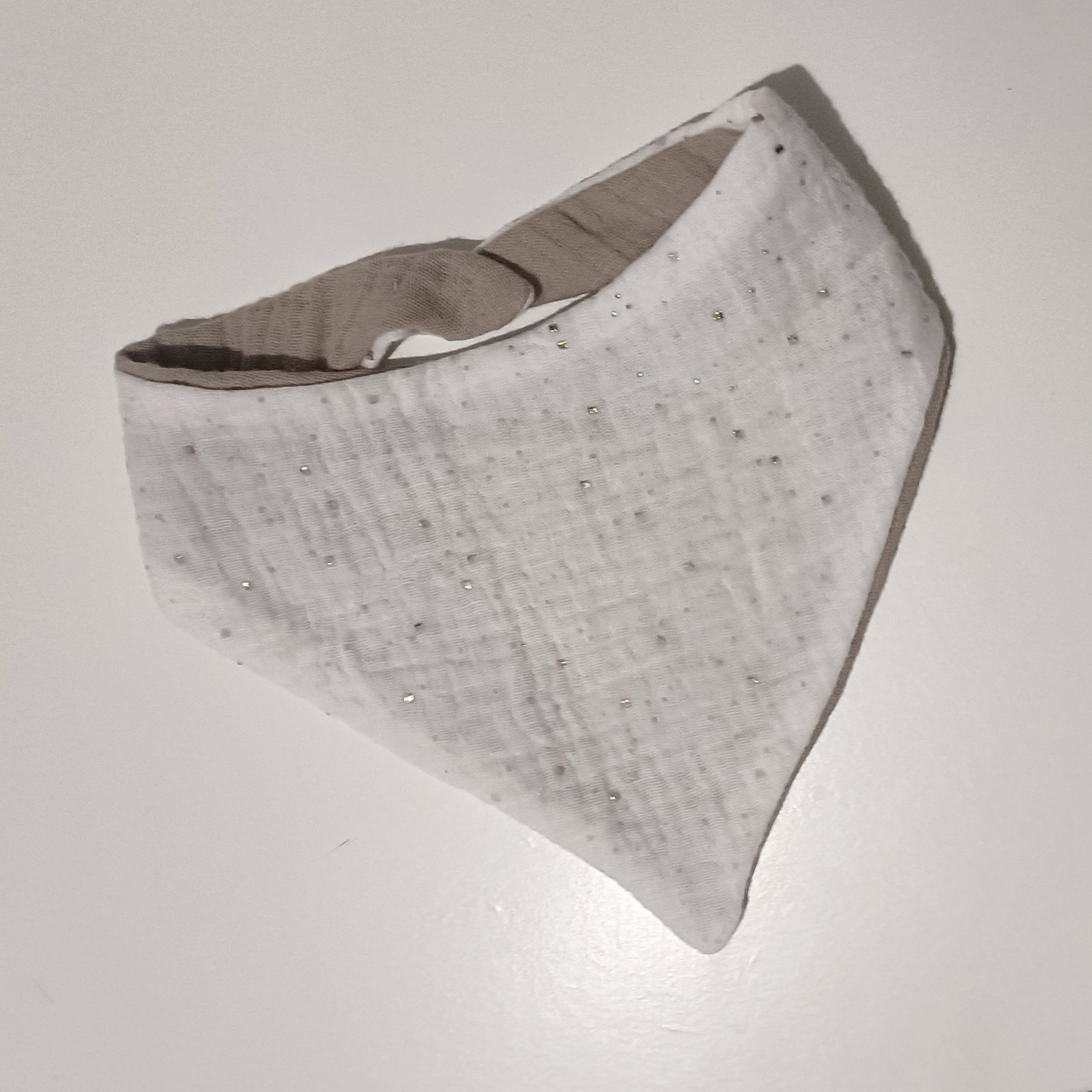 Bavoir bandana blanc pur parsemé de pois argentés scintillants.