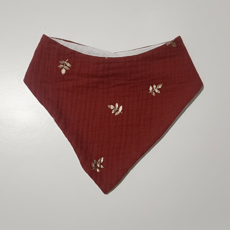 Bavoir bandana couleur terracotta rouille avec jolis motifs de feuilles dorées.