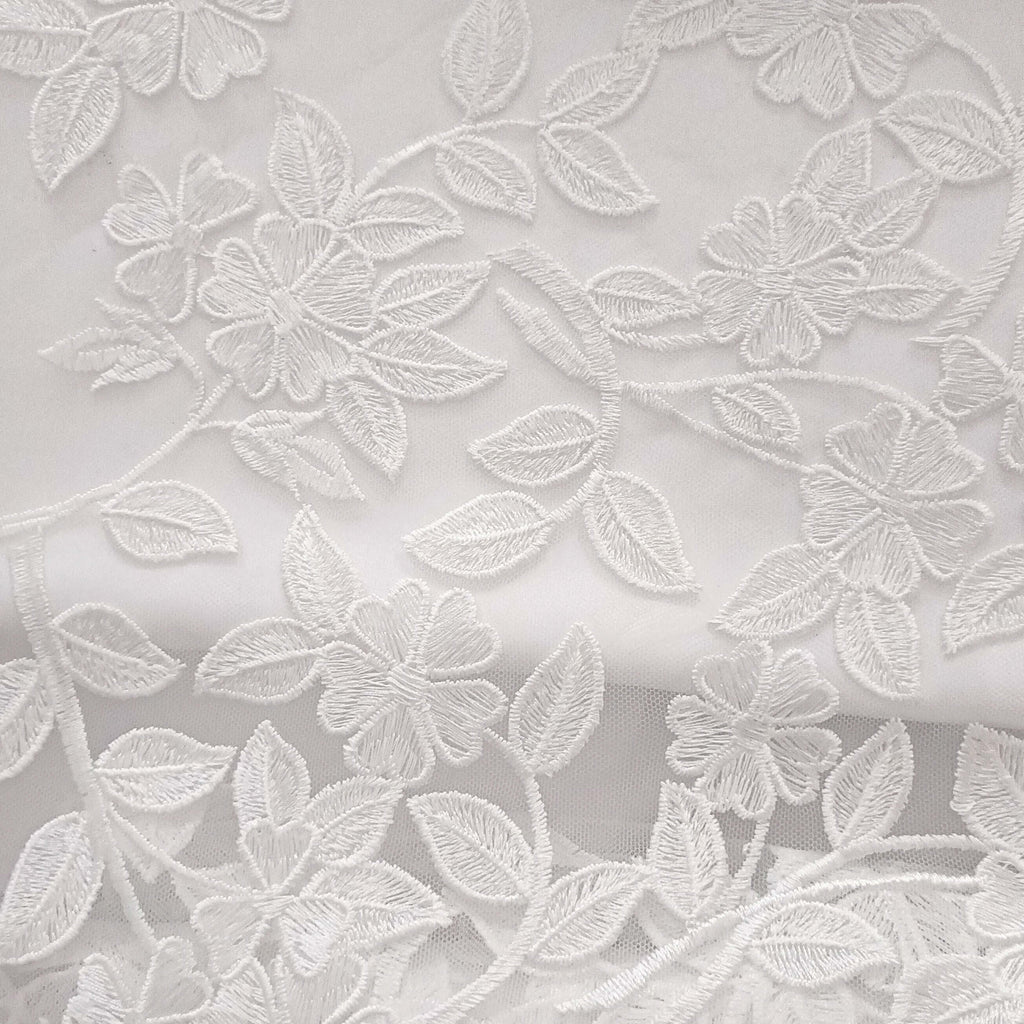 Tissu blanc brodé motif floral, dentelle fine idéale accessoires bébé ou mode enfant.