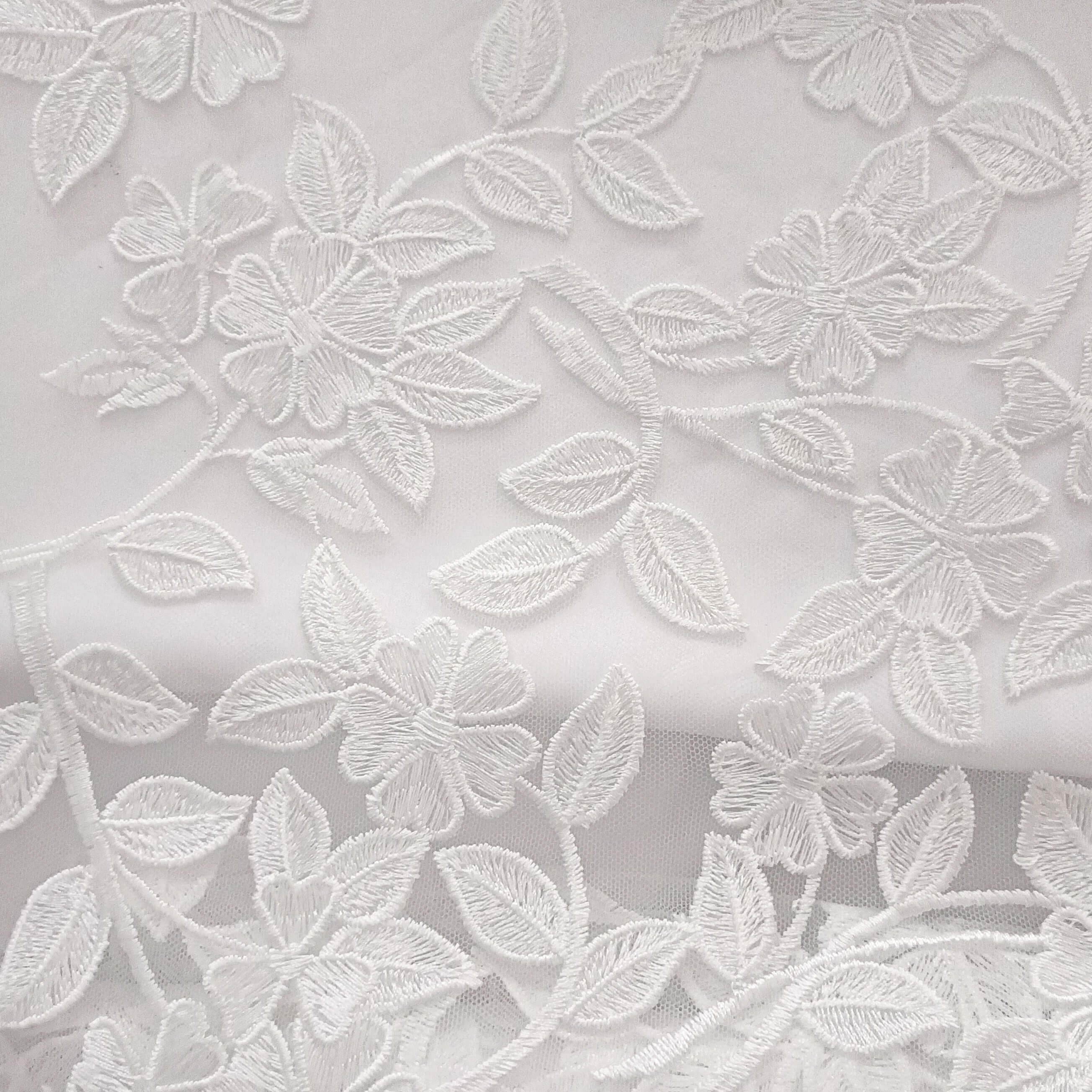 Tissu blanc brodé motif floral, dentelle fine idéale accessoires bébé ou mode enfant.