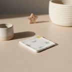 Lingette lavable individuelle posée sur une table à langer, motif étoiles et lunes douces pour la toilette de bébé.