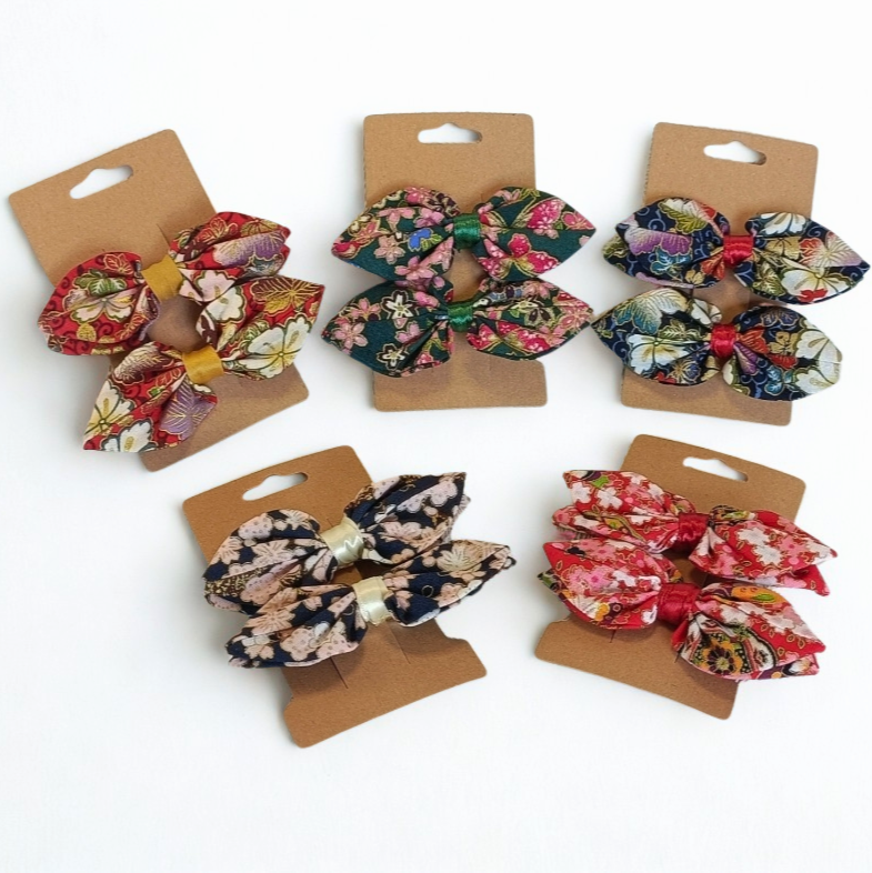 Vue d'ensemble de la collection de barrettes à nœud en tissu japonais floral. Assortiment de 5 motifs colorés (rouge, vert, bleu) sur cartes kraft.