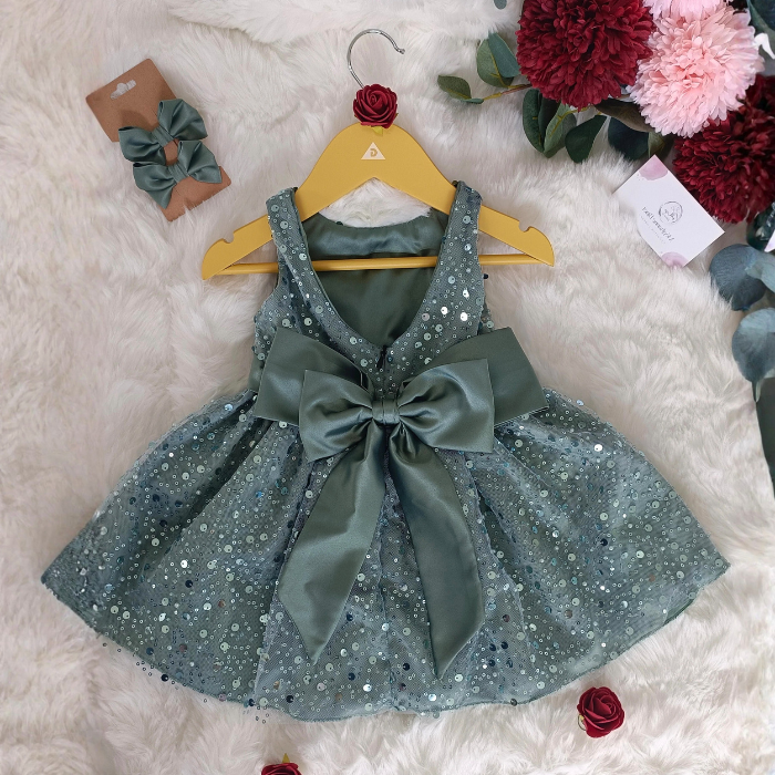 Gros plan sur le magnifique nœud en satin au dos de la robe vert sauge. Vue à plat montrant la qualité des finitions artisanales.