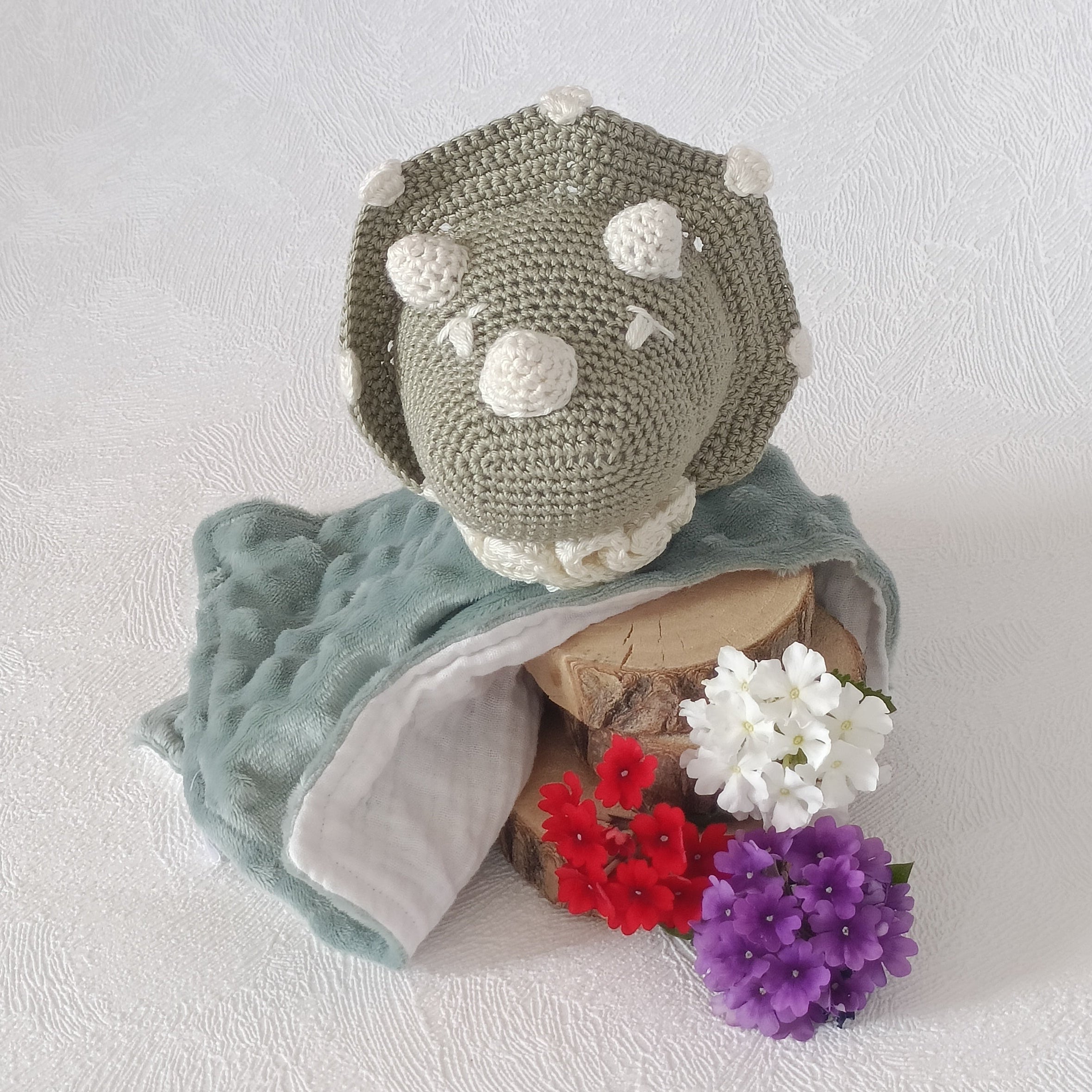Doudou dinosaure au crochet vert sauge et blanc avec col crème, lange double face minky vert sauge et mousseline blanche, vue de face