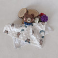 Doudou ours au crochet posé à plat sur lange double face — recto motif oursons avec arcs-en-ciel bleus, verso minky blanc à bulles