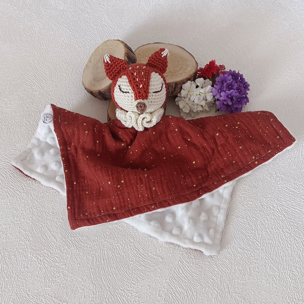 Doudou renard au crochet posé à plat, lange mousseline terracotta à paillettes dorées doublé minky blanc