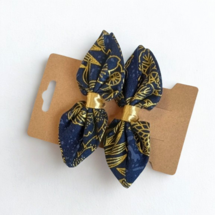 Duo de barrettes à cheveux forme nœud en tissu japonais bleu marine avec motifs floraux et feuillages dorés. Centre du nœud en ruban or.