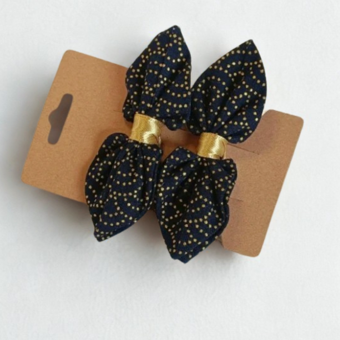 Duo de barrettes à cheveux forme nœud en tissu japonais bleu marine avec motif traditionnel de vagues en pointillés dorés. Centre du nœud en ruban or.