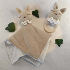 Doudou lapin en coton beige et hochet bébé au crochet, décorés de feuilles sur fond clair.