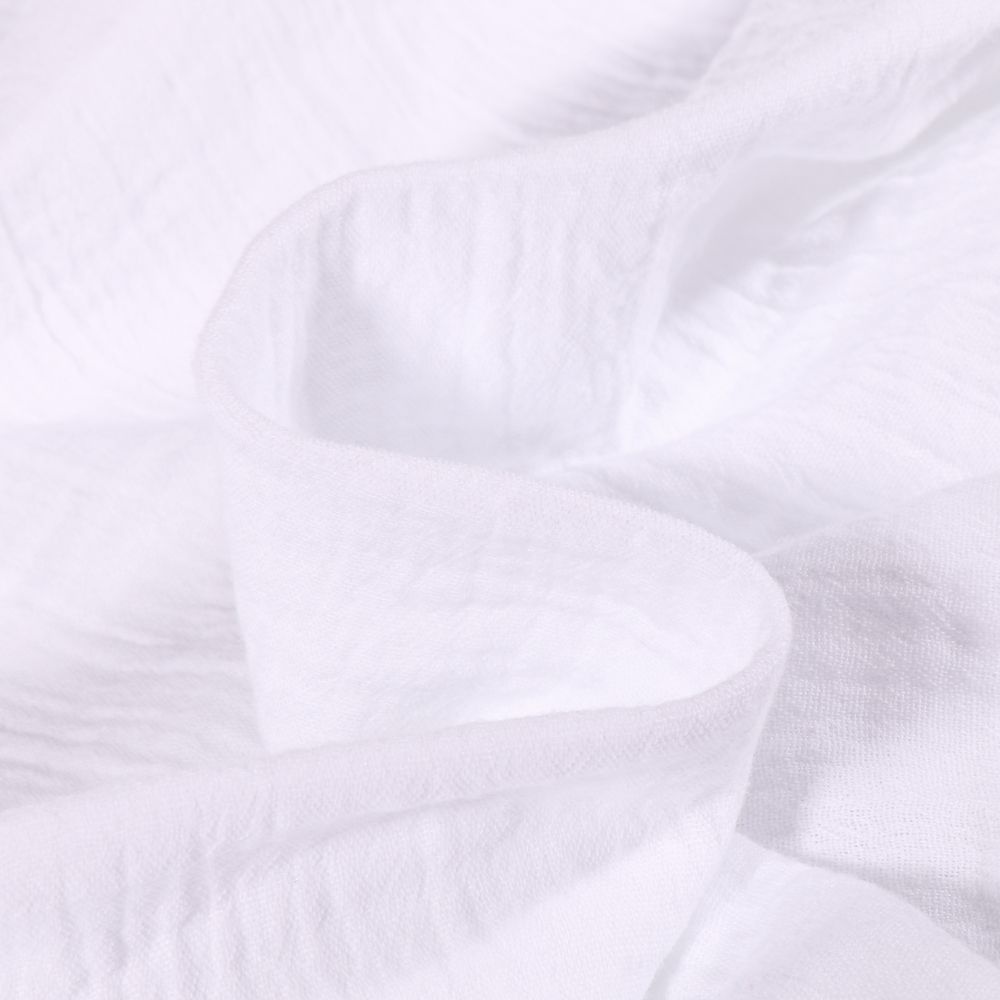 Tissu double gaze de coton blanc, texture légère et respirante pour langes et vêtements.