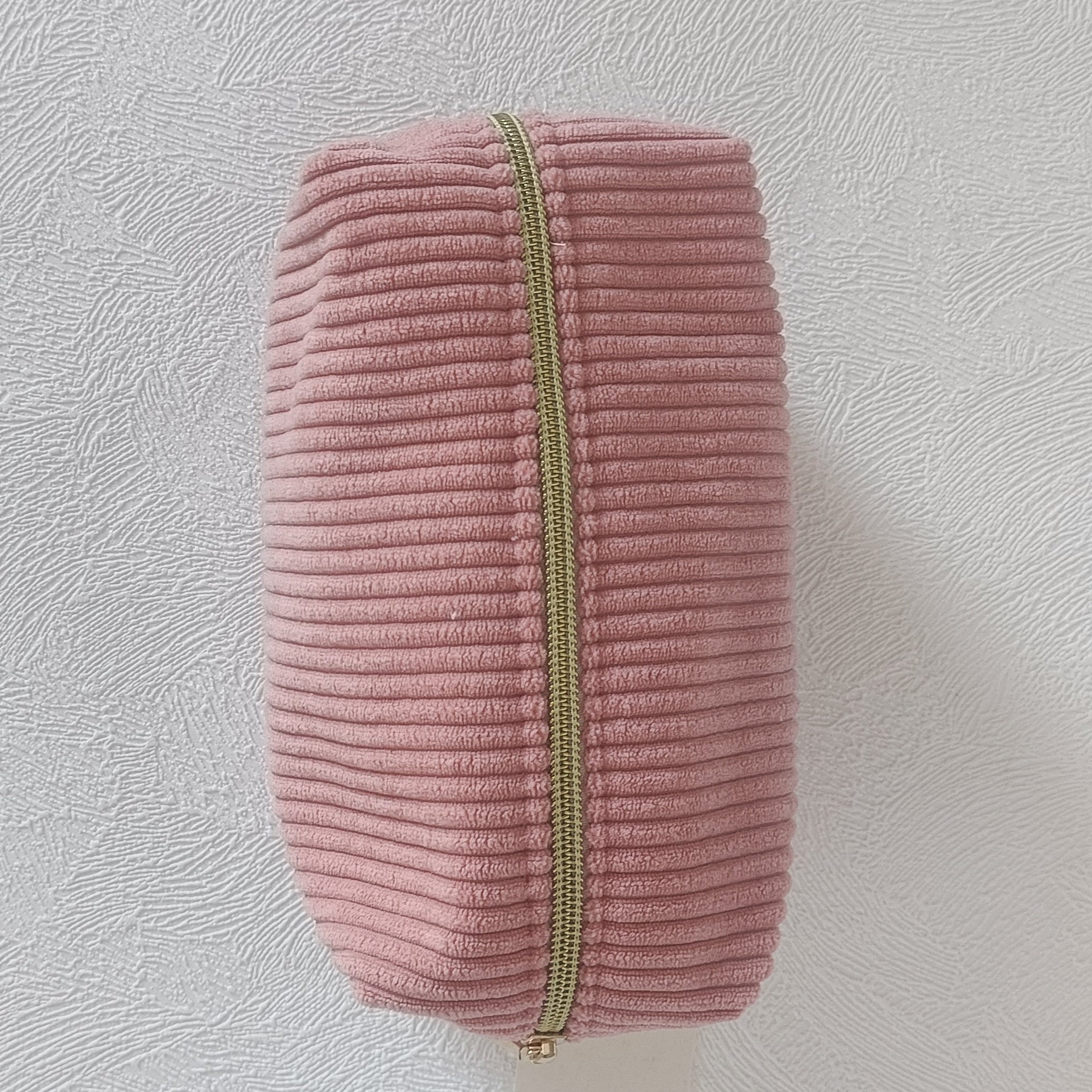 Vue du dessus de la grande trousse en velours côtelé vieux rose avec zip doré centré