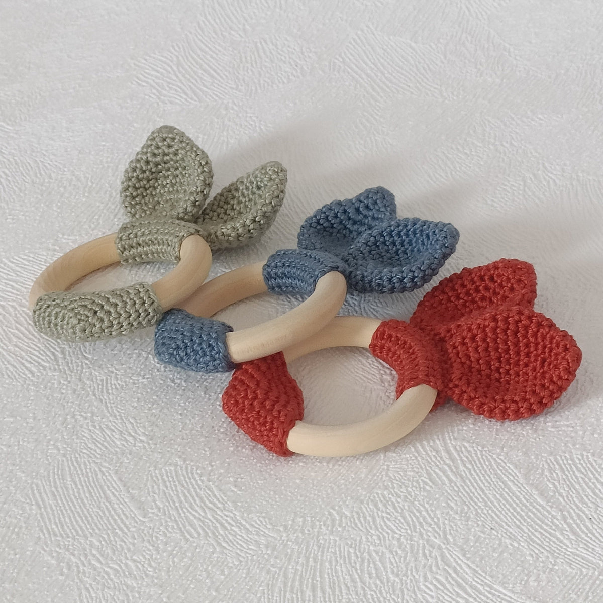 Trio de hochets anneaux en bois avec nœud au crochet — vert sauge, bleu ardoise et terracotta