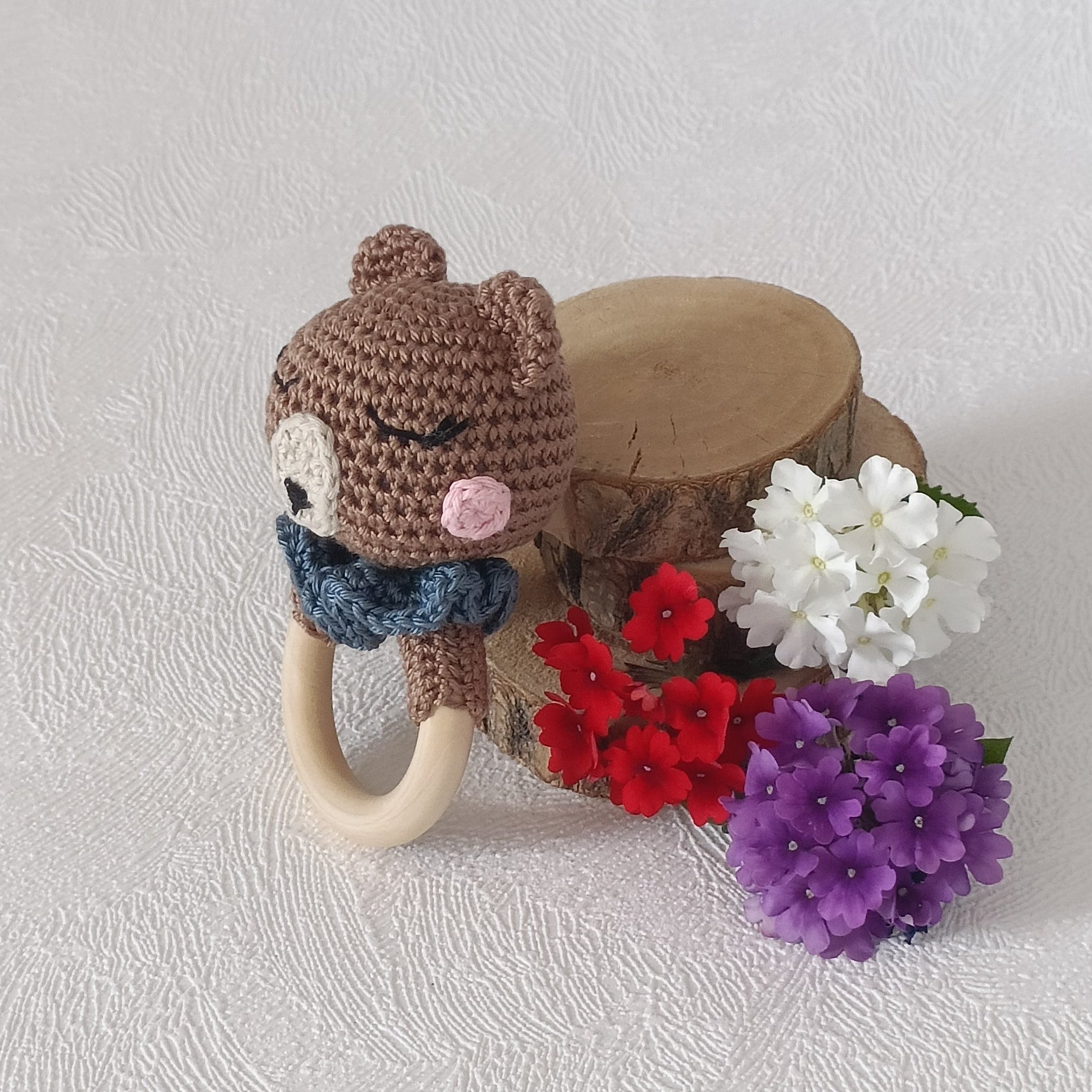 Hochet anneau en bois naturel avec ours au crochet marron et col bleu, vue de profil