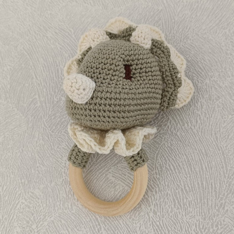 Détail du hochet dinosaure au crochet fait main vert sauge et écru