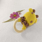 Vue arrière d'un hochet girafe artisanal en crochet montrant les détails des taches marron.