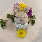 Vue rapprochée du hochet lapin beige avec grandes oreilles et collerette blanche
