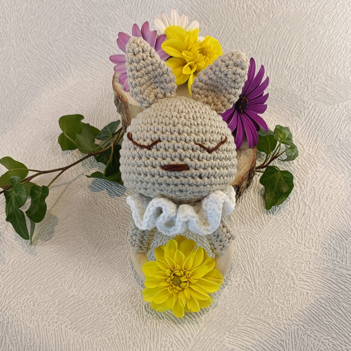 Vue rapprochée du hochet lapin beige avec grandes oreilles et collerette blanche