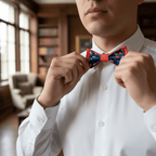Plan rapproché d'un homme ajustant son nœud papillon rouge et bleu à motifs fleurs sur une chemise blanche pour une finition élégante.
