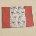 Vue dépliée d'un protège carnet de santé montrant le tissu central aux motifs lapins avec couronnes de fleurs et les rabats latéraux couleur corail.