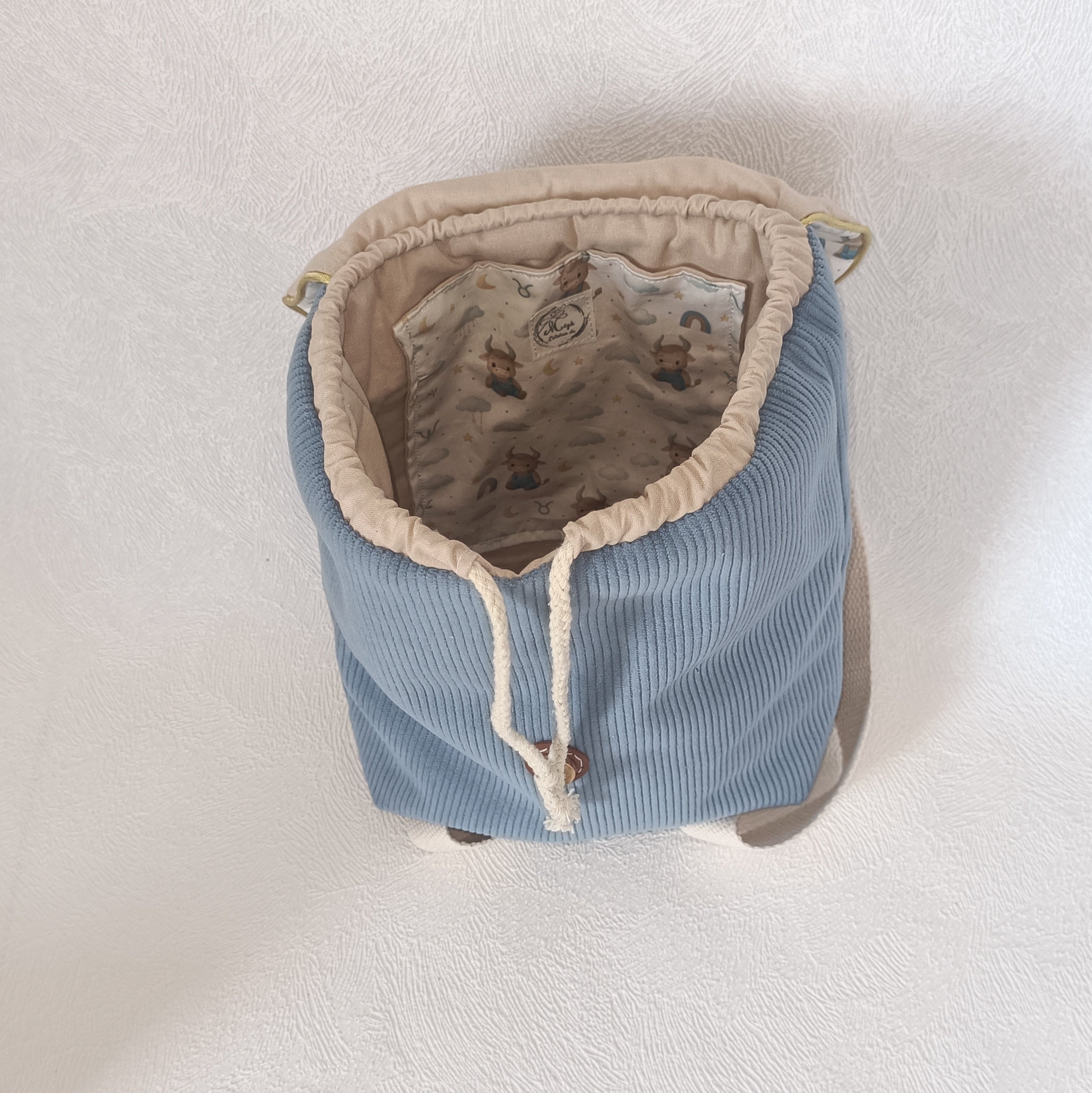 Intérieur du sac à dos enfant avec doublure coton imprimé taureau céleste et poche intérieure assortie