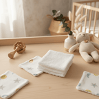 Lingettes bébé en coton, motifs lune et étoiles, sur table en bois près d'un doudou tricoté dans une chambre d'enfant.