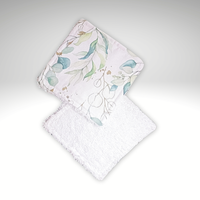 Vue recto-verso de deux lingettes lavables : une face coton imprimé eucalyptus doré et une face éponge de bambou blanche absorbante.