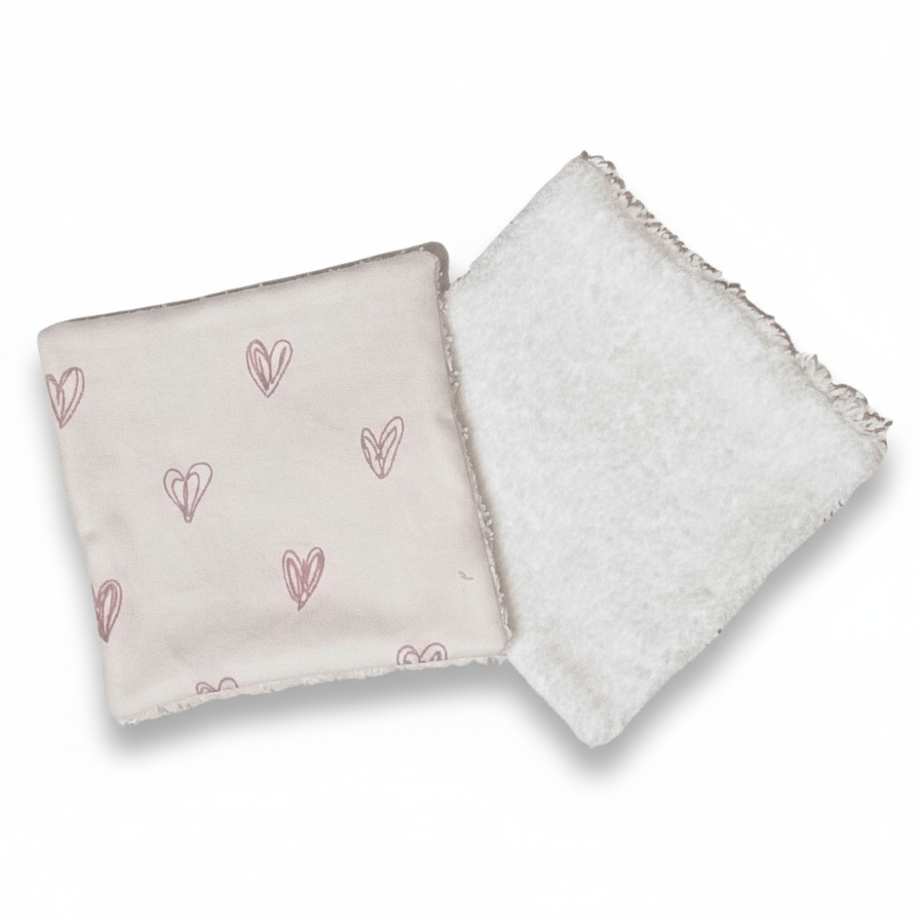 Vue recto-verso : tissu coton imprimé cœurs roses et face éponge blanche pour le soin de bébé.