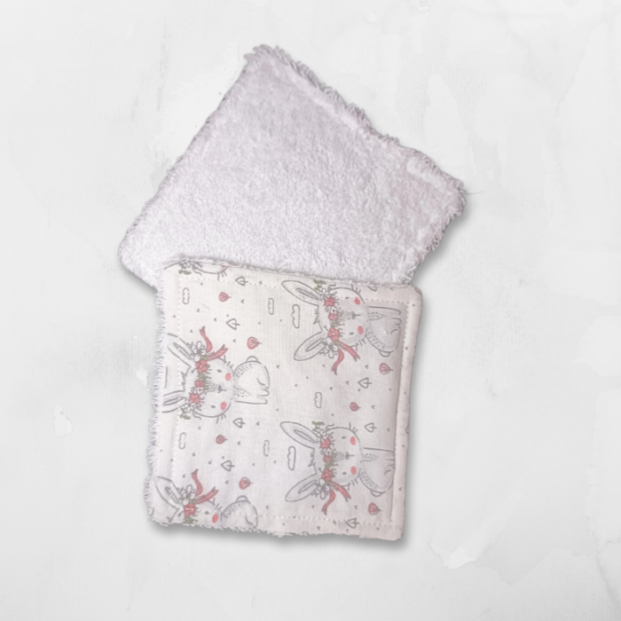 Vue recto-verso montrant la double face : tissu à motif lapins mignons et éponge de bambou blanche absorbante pour le change.