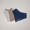 Trio de bavoirs bandana pour garçon en double gaze : bleu marine personnalisé Raphaël, beige sable et blanc à pois argentés.