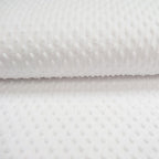 Tissu minky à pois relief blanc pur, texture moelleuse idéale pour la layette et les soins bébé.