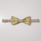 Nœud papillon double épaisseur beige et fleuri jaune présenté à plat montrant sa forme symétrique et son attache.