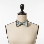 Nœud papillon bicolore vert et motif fleurs présenté sur un buste de mannequin couture sur fond blanc
