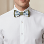 Homme portant un nœud papillon double épaisseur vert olive et tissu floral bleu sur une chemise blanche pour une tenue de mariage.