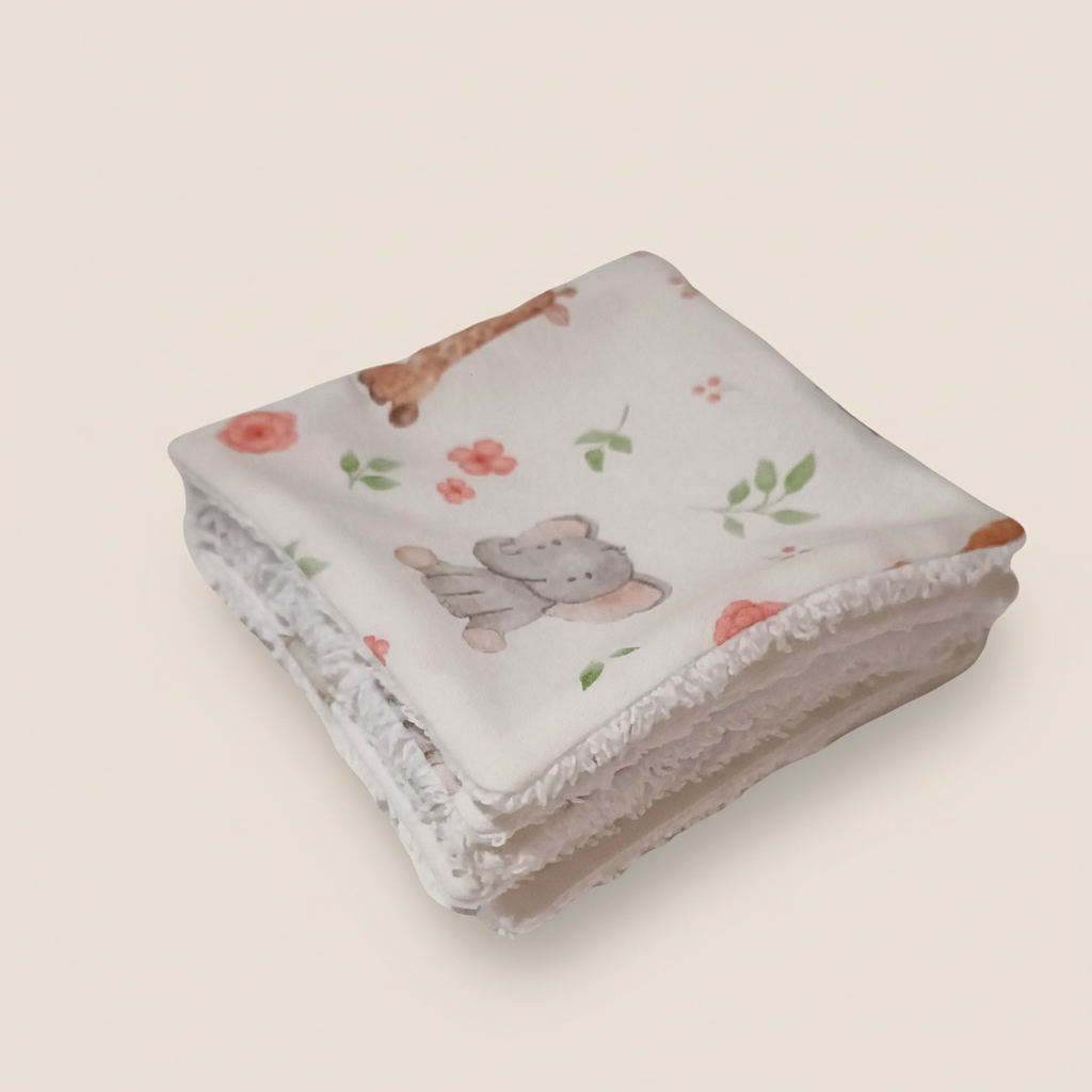 Pile de lingettes lavables montrant l'épaisseur et le moelleux de l'éponge de bambou. Motif savane tons ocres.