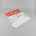 Couverture de naissance personnalisée avec le prénom Eva brodé en blanc sur la bande couleur terracotta, assortie au thème animaux de la jungle.
