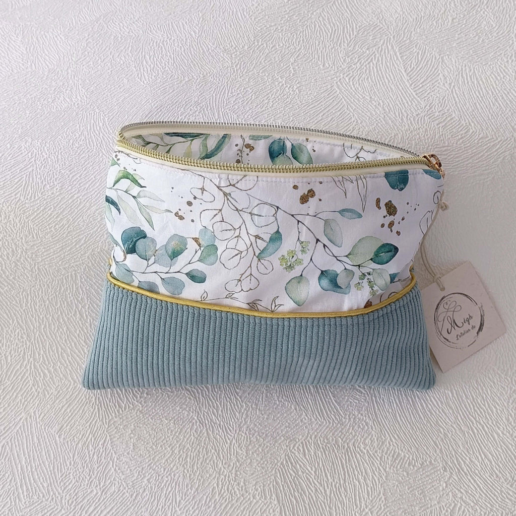 Petite pochette plate bi-matière ouverte, dévoilant une finition soignée avec une doublure intérieure au motif végétal assorti.