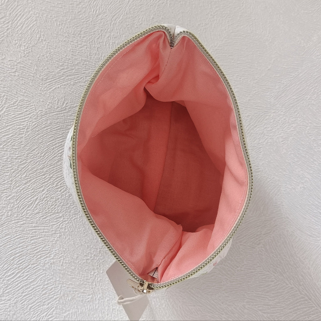 Intérieur de la pochette plate avec doublure rose saumon et zip doré