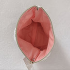 Intérieur de la pochette plate avec doublure rose saumon et zip doré