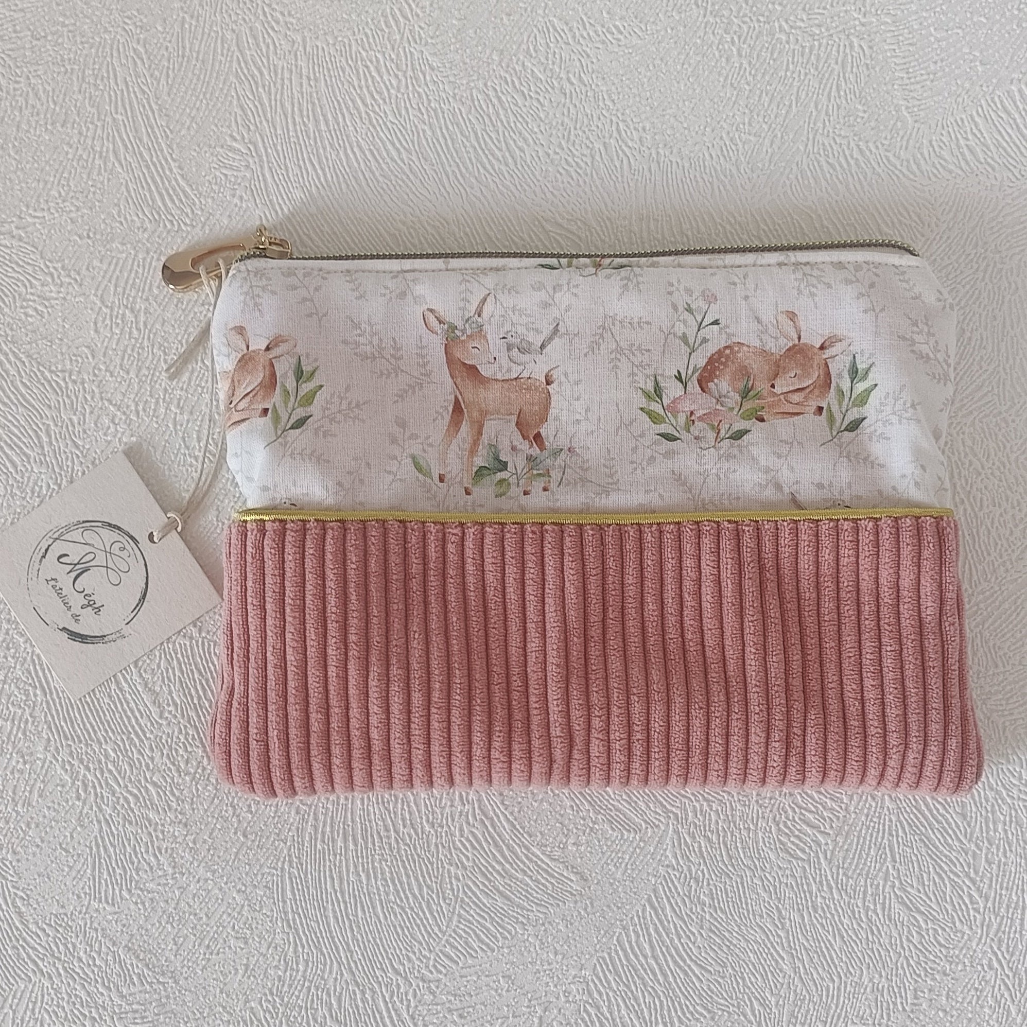 Vue à plat de la pochette bimatière faons aquarelle et velours côtelé vieux rose avec zip doré