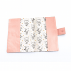 Protège carnet de santé étalé à plat, révélant l'intégralité du tissu à motif souris ballerines et petits cœurs dorés, bordé de tissu rose.