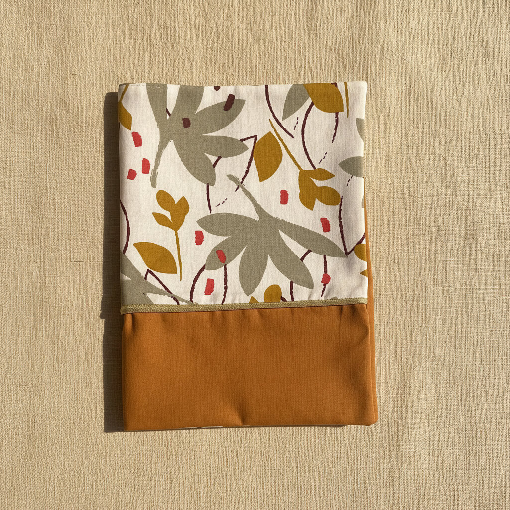 Protège carnet de santé aux couleurs automnales avec liseré doré, motif végétal chic et moderne pour un trousseau de naissance mixte.