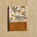 Protège carnet de santé aux couleurs automnales avec liseré doré, motif végétal chic et moderne pour un trousseau de naissance mixte.