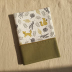 Protège carnet de santé personnalisé avec le prénom Arthur brodé sur tissu vert kaki, surmonté d'un motif automnal avec renards et écureuils.