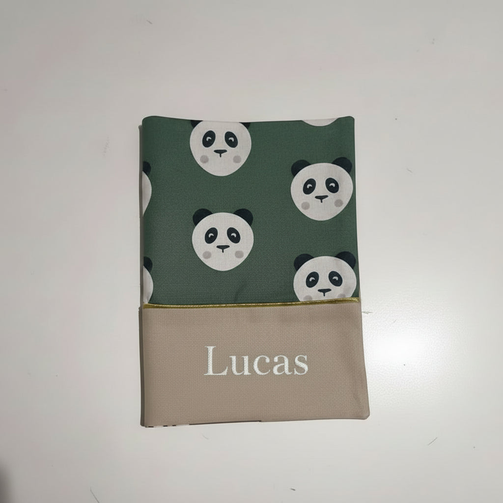 Protège carnet de santé vert à motif têtes de panda avec le prénom Lucas brodé en blanc sur la partie inférieure beige.
