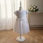 Robe de baptême fille blanche avec haut en crochet et jupe en organza, présentée de face sur mannequin.