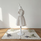 Vue cote de la robe Camille vichy beige sur mannequin, mise en scène avec lavande et gypsophile sur tissu lin