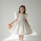 Robe Camille en vichy beige portée par une fillette tenant un panier en osier, vue de face